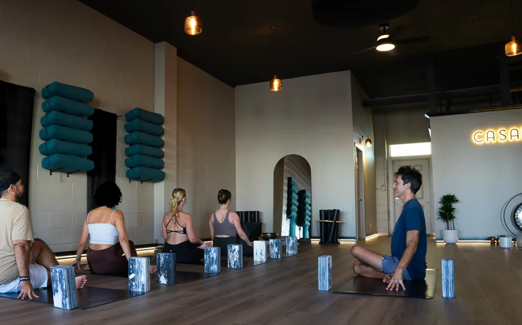 A class gathered on their mats in the CASAPRANA studio