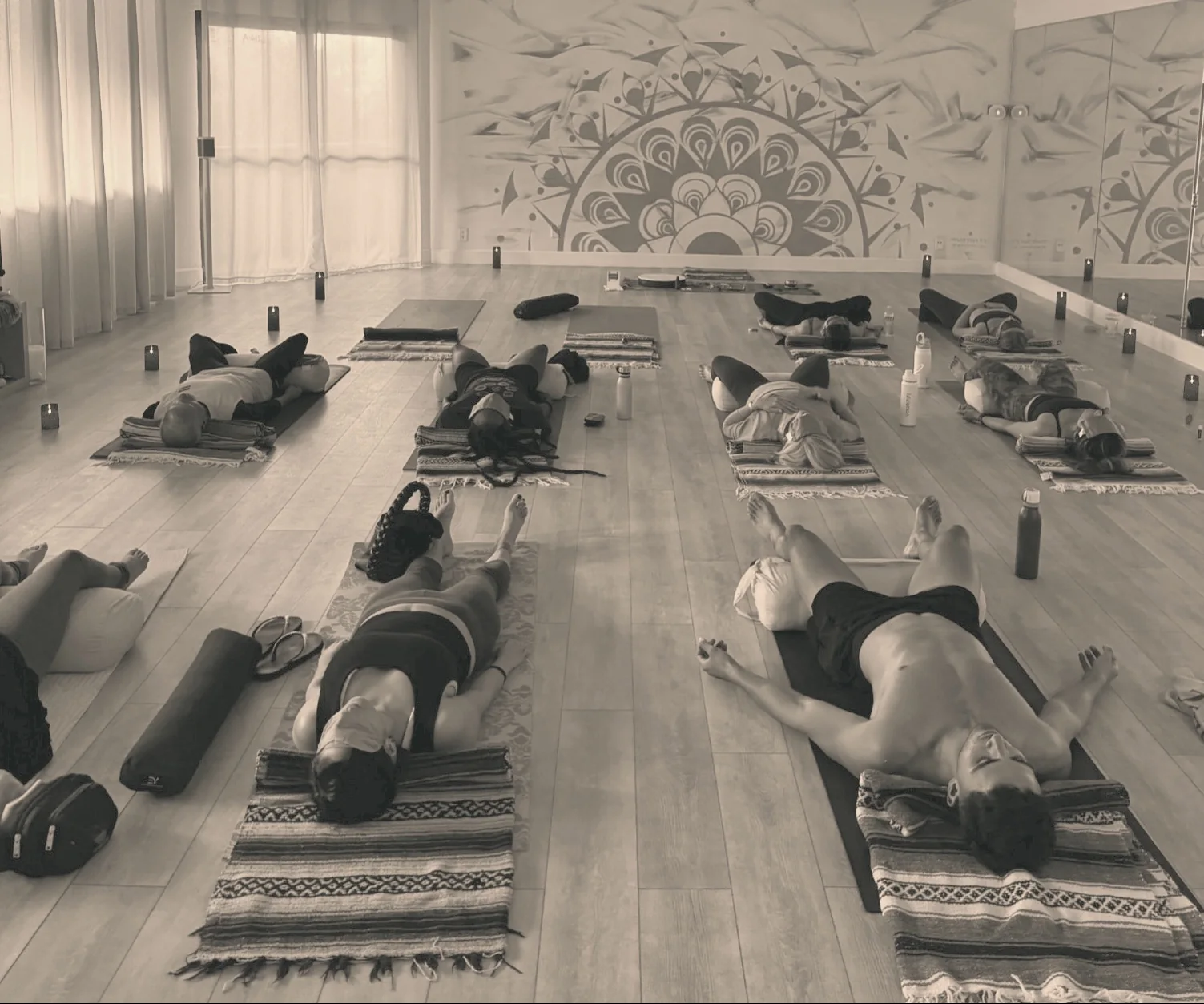 A group resting on mats during a soundbath class at CASAPRANA